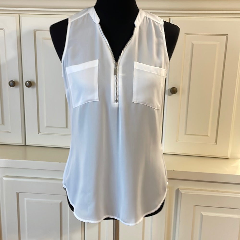 SOHO white sleeveless blouse with zippered front and two pockets. Size x-small.